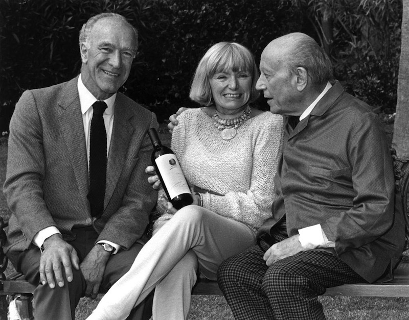 玛格丽特·蒙大菲（Margrit Mondavi）夫人，她丈夫罗伯特·蒙大菲（右）与木桐酒庄前庄主飞利浦男爵（Philippe de Rothschild，左），她手中的即是曾经由美法两大葡萄酒巨头合作的Opus One